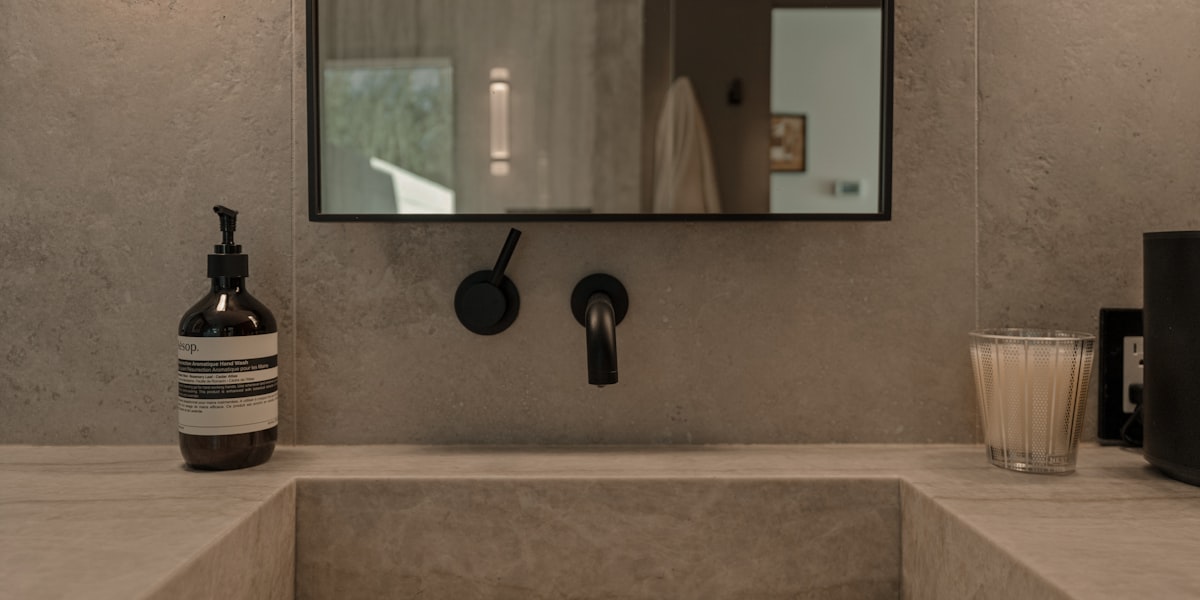 Modern luxury bathroom with concrete sink and contemporary plumbing fixtures
